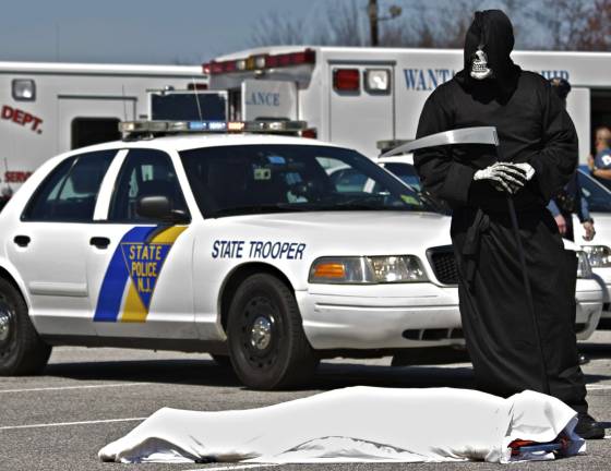 Staged fatal crash The Grim Reaper stands watch over the drunk driving 'victim' at High Point High School.