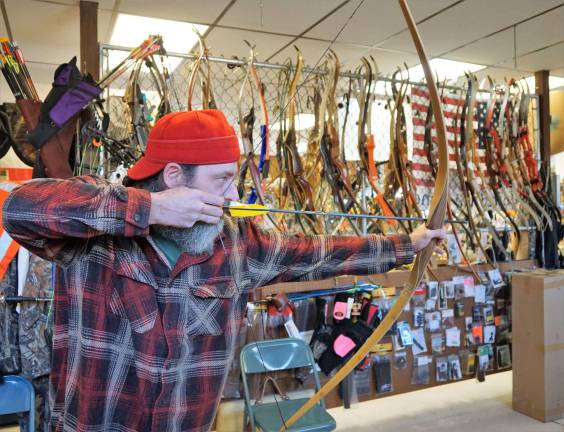 Hunters fighting back against bear protesters Mike tests out a bow for a customer.