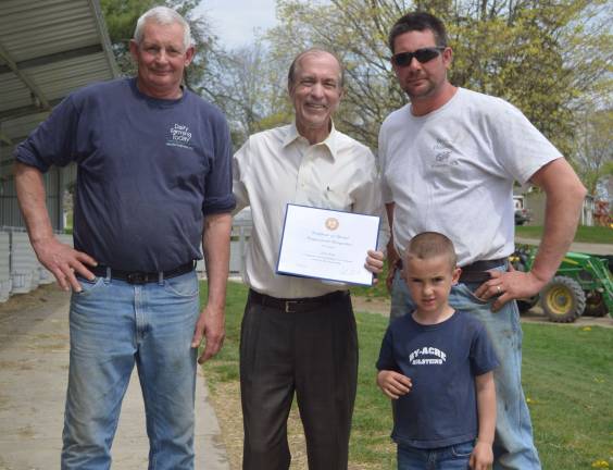 U. S. Rep. Garrett presents Henry Byma with a certificate of Congressional Recognition, alongside his father, Richard, and son.