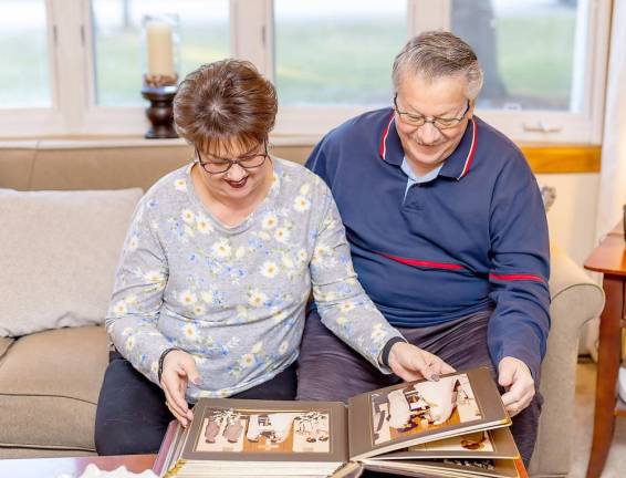 Terry and Ken Reilly of Vernon look at their wedding photos.