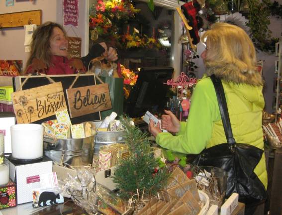 Local businesses celebrated on Saturday PHOTOS BY JANET REDYKE Highland Flowers owner Lori Struck wraps a present for customer Lori Roskelly of Vernon on Small Business Saturday.