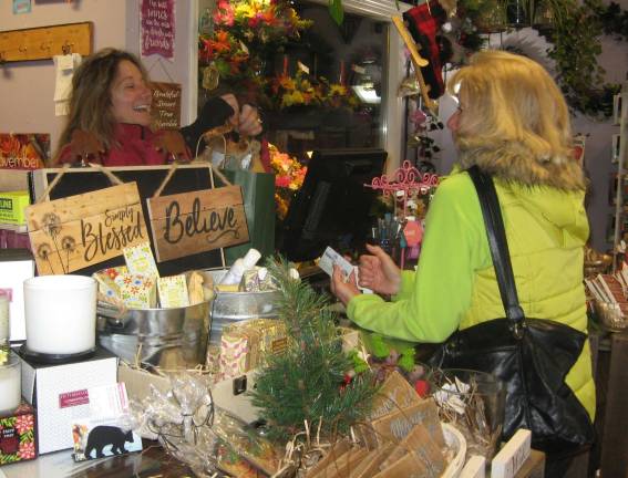 PHOTOS BY JANET REDYKE Highland Flowers owner Lori Struck wraps a present for customer Lori Roskelly of Vernon on Small Business Saturday.