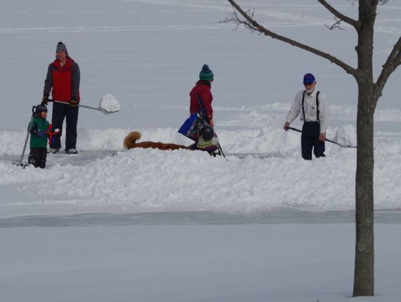 Early Sunday afternoon, people in Highland Lakes made the most of a snow-covered lake. This group is shown shoveling the snow from what used to be their hockey rink.
