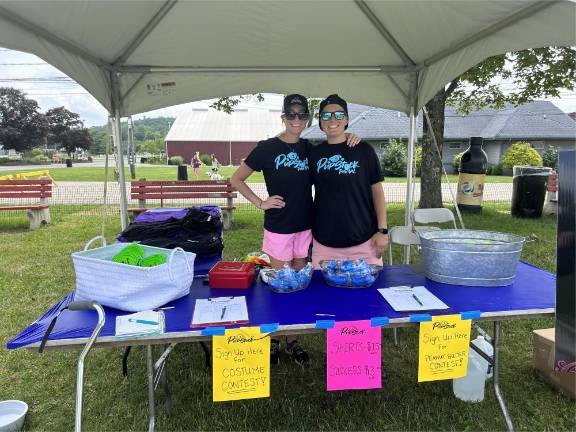 Dogs have their day Melissa and Nicole Soucy sell T-shirts and help people sign up for the costume contest and peanut butter eating contest.