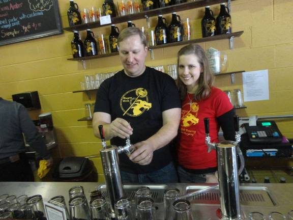 Angry Erik grand opening a hit, despite snow Photos by Scott Baker Erik and Heide Hassing pour samples of their newly debuted beers during their grand opening.