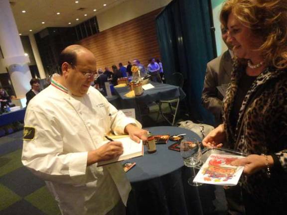 Harvest Fest raises funds for the Growing Stage Children's Theater Celebrity chef Sal Scognamillo of the renowned Patsy's Italian Restaurant in Manhattan signs a copy of his cookbook for Penny Hollenstein, of Fredon.