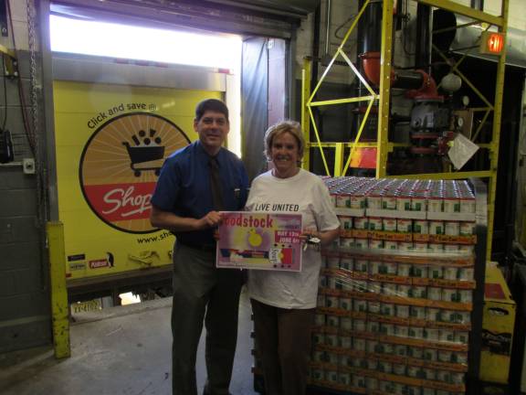 John Reinhart, general store manager at Newton ShopRite, joins Mary Emilius, United Way of Northern New Jersey, to turn over the donated ShopRite canned goods