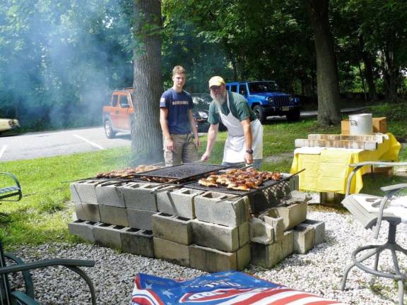 Rotarian Paul Katterman is shown working the grill with his son, Zachary.