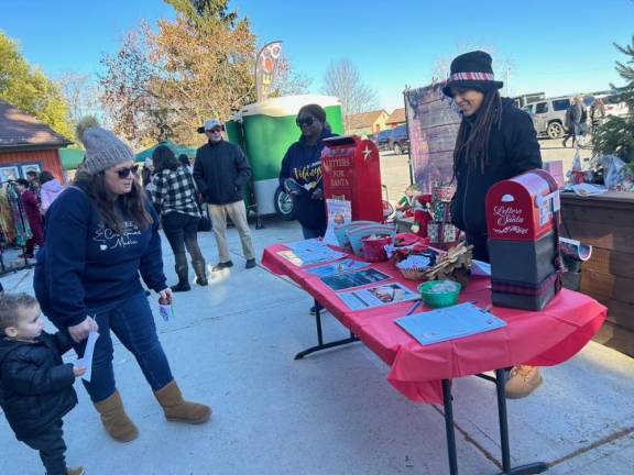 Meg Wahnon, right, executive assistant in the Vernon Township Recreation Department, mans a table collecting letters to Santa. (Photo by Daniele Sciuto)