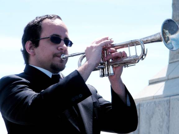 Antonio Del Valle performing 'Taps' on the trumpet to honor all veterans during the 'Salute to Our Veterans' ceremony.