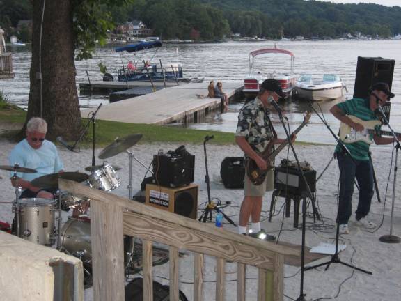 PHOTO BY JANET REDYKEFred Van Keuren on drums, Ken Neill on bass and Jeff Gaynor on guitar of the group Smooth Sailing play on the beach at Lake Mohawk in Sparta on Aug. 26.