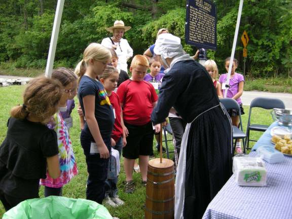 Children learn how to churn butter at the Vernon Township Historical Society&#x2019;s Hands-On History Camp.