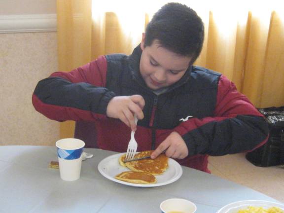 Owen Baez enjoys his pancakes with enthusiastic gusto.