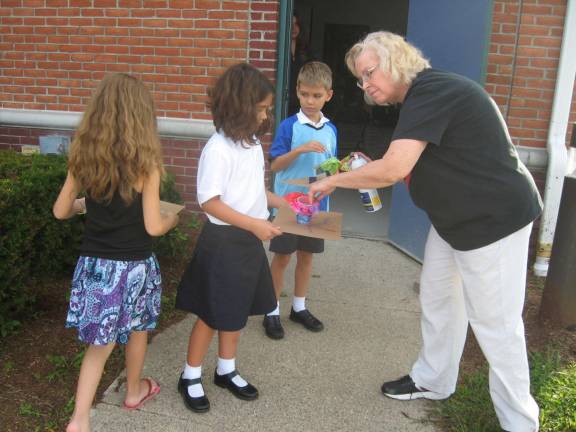 Diana Arnold of the library helps spray starch on children&#x2019;s &#x201c;glass&#x201d; sculptures.