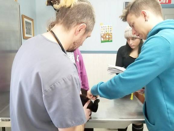 Scott Gaydos, Julia Ragno, and Krystian Kipp take Jilly-May's measurements for a prosthesis.