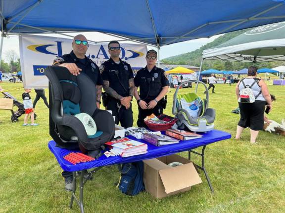 Vernon police officers, from left, Stephen Rovetto, Nick Gonzalez and Parker Shade handed out coloring books to children.at the L.E.A.D. (Law Enforcement Against Drugs) table.