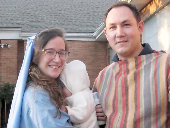 Our Lady of Fatima parishioners tell the story of Christmas The Vitulli family — Chiara, James and baby James — portray the Holy Family of Mary, Joseph and baby Jesus (Photo by Janet Redyke)