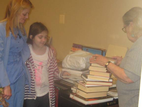 From left: Lisa Christien and Lizzy May finalize their book deals with Friends of the Dorothy Henry Library President Lynne La Carrubba.