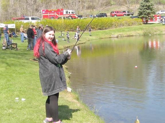 A beautiful day for fishing Success! Olivia from Vernon reels in a catch. (Photo by Janet Redyke)
