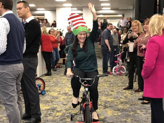 One of Santa’s helpers rides a newly assembled bike through the Selective Insurance cafeteria in Branchville. (Photos by Kathy Shwiff)