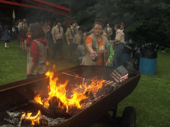 Photos by John Church Members of Cub packs 90 and 298, Boy Scout Troop 187 and Girl Scout Troop 897 added flags to the fire.