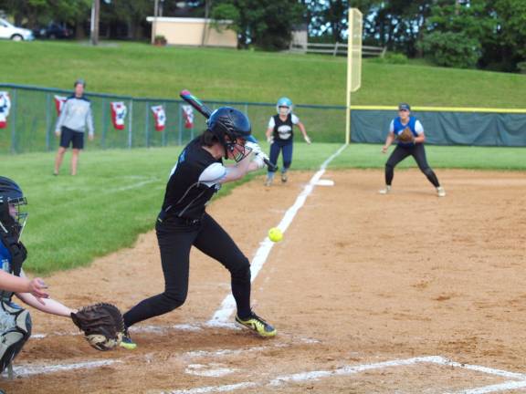 Black batter Ally Latham hits the ball down the foul line early in the game. Latham attends Vernon Township High School in Glenwood.
