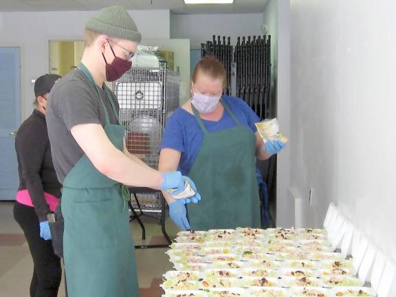 Paul Doumanis (left) and Kelly Immesberger dole out salad ingredients. (Photo by Janet Redyke)