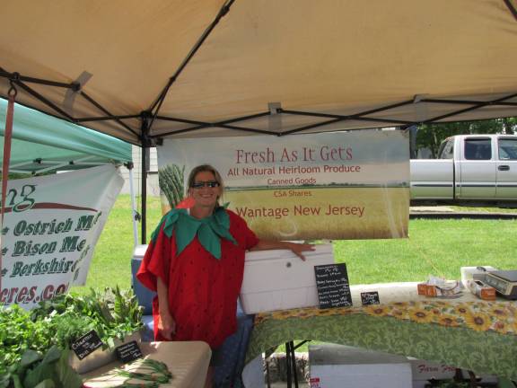 Shawna Bengivenni, of As Fresh as it Gets, poses with her veggies. She's wearing a Strawberry suit as Saturday was the markets Strawberry Festival. Bengivenni's farm is in Wantage where she lives with her husband, Lou, and their goats.