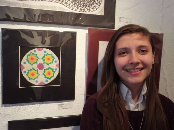 Getting creative Artist Felicia Kurish next to her creation called "Many Suns" which is made with sand. Kurish is a seventh grade student at Immaculate Conception Regional School in Franklin.