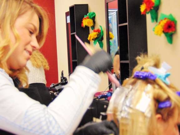 Hairdresser Randi Tiger highlights a clients hair.
