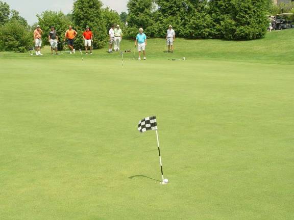 Putting Contest Golfer watches as his &#x201c;practice&#x201d; putt goes in the hole. It did not count in the contest!