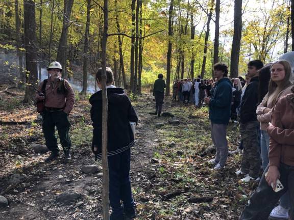 Lighting a fire under science students George Finger, section fire warden A7 with the New Jersey Forest Fire Service, answers a student’s question after the prescribed burn. (Photo by Kathy Shwiff)