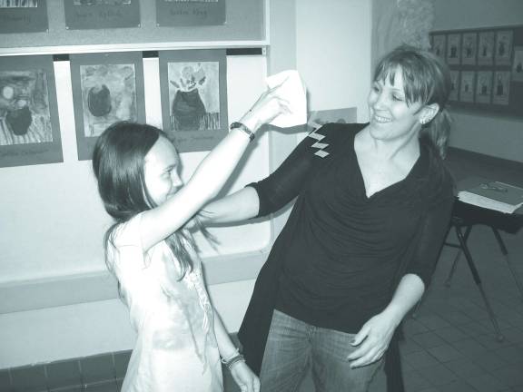 Paper Sculptures take center stage at Family Art Night Palmer Papson surprises Mom with her puppet.