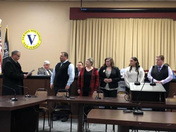 State Sen. Parker Space, left, administers the oath of office to members of the Vernon Township Ambulance Squad.