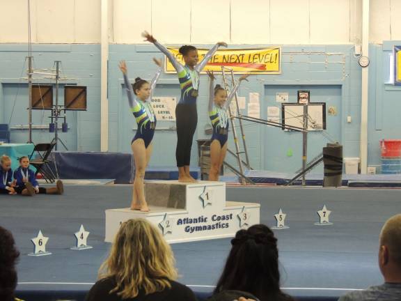 Garden Gator Bronze take gold in debut meet Lily Kucks, Ainsley Mitchel and Emily Harms, all from Sparta, go 1-2-3 for Floor Exercise.