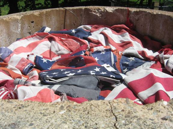 PHOTOS BY JANET REDYKETattered American flags await the start of the ceremony on June 24.