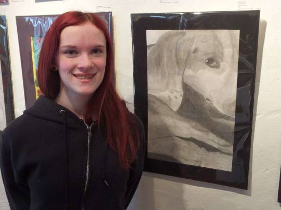 Getting creative Kittatinny Regional High School artist Jessica Taylor next to her dog sketch. The portrait is of her pet beagle, Lily.