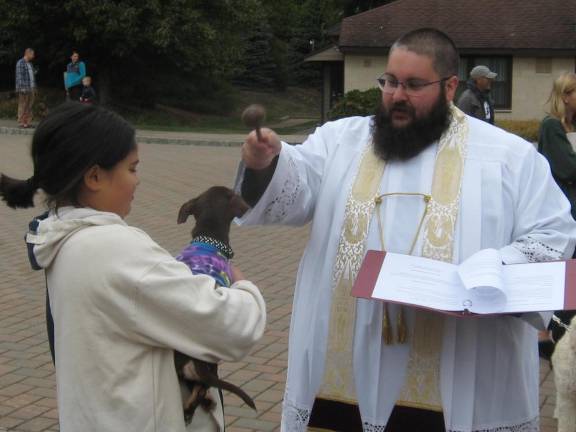 Fr. Chris blesses four month old Coquito, meaning Little Coconut, family pet of the Feliciano family.