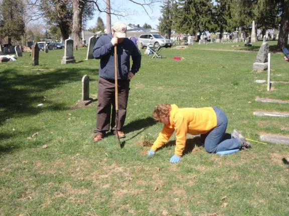 DAR cemetery dig DAR member Wendy Wyman begins to dig after Richard Ziccardi has tested the earth and found a covered marker in the area.