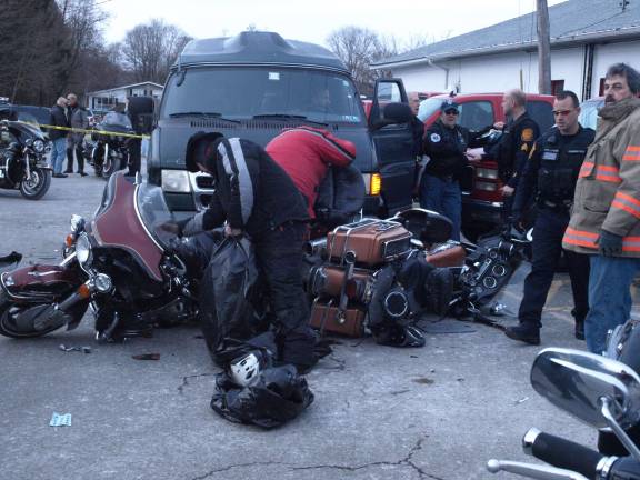 Van drives into motorcyclists Photos by John Church The Ogdensburg Police and friends of the victims preparing to move the damaged motorcycles.