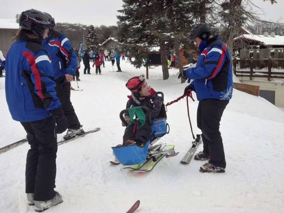 PHOTOS COURTESY JOHN WHITING Nick Cerrato getting adaptive ski instruction from members of the Camelback Ski Area staff.