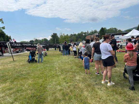 People wait in line to climb on the ladder of the McAfee Fire Department’s truck.