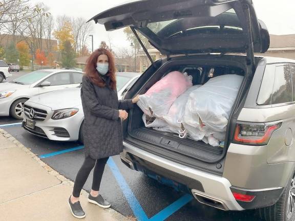 Winter drives focus on coats and homebound seniors Project Self-Sufficiency board member Sue Murphy donates new coats to the agency (Photo provided)