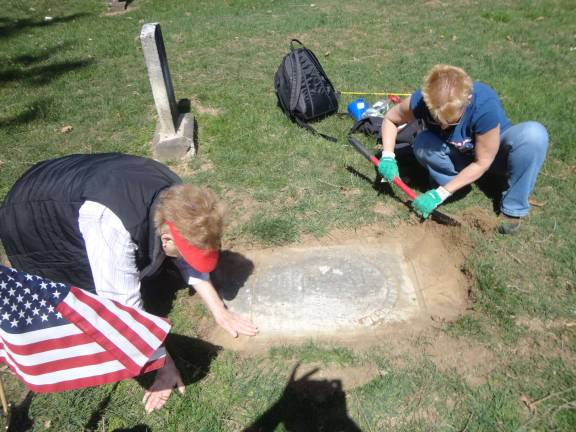 DAR cemetery dig Nancy Malone, left, and Lisa Permunian work to uncover the grave marker of William Van Blarcum.