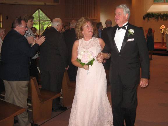 Tragedy brings couple together PHOTO BY JANET REDYKEThe newly married couple Kathy and Fred Barth walk together down the aisle of St. Francis de Sales Church after their ceremony.