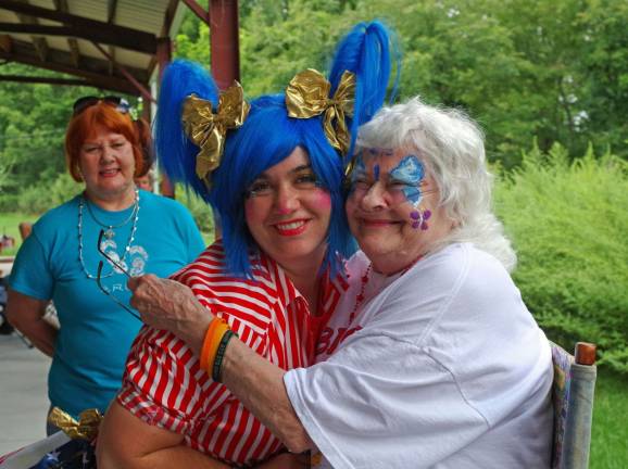 Face painting is popular with the kids, but Vernon&#xfe;&#xc4;&#xf4;s senior citizens love it too. Here Pixie Pop the Clown gets a hug from grateful Vernon senior Bunny Music.