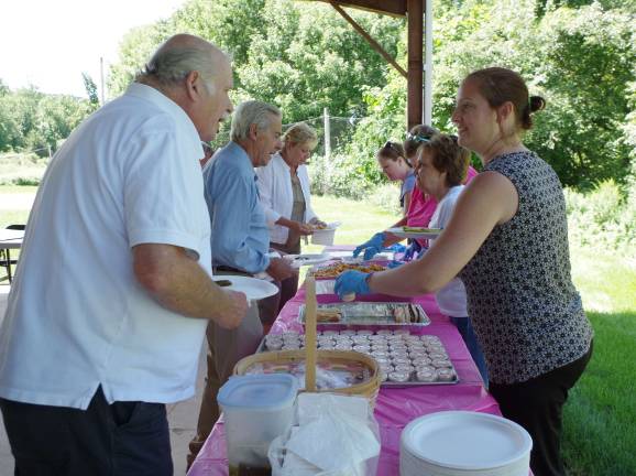 At left, Phil Badu of Highland Lakes is served by Christina Marks of the Sussex County Department of Human Services, Division of Senior Services.