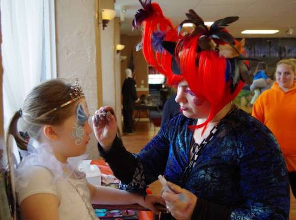 Beth Ann Thomas, 9, is shown getting her face painted by Kerry Tobin of Highland Lakes, better know as Pixie Pop the Clown.