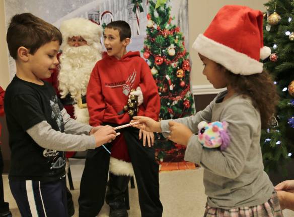 Jordyn Trinkleback of Sussex is Santas helper giving a candy cane to Bennett Accavallo.