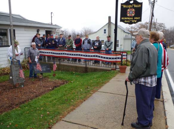 Veterans and their families listen as Quartermaster Bob Constantine, a former Post Commander read from a message entitled &quot;Remembering a Veteran&quot; written by veteran Jochem R. Kresse of Clifton.
